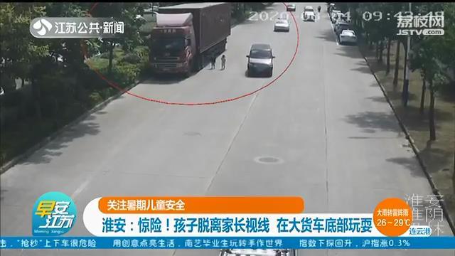 孩子脱离家长视线，钻入大货车底部玩耍 多亏一辆警车驶来