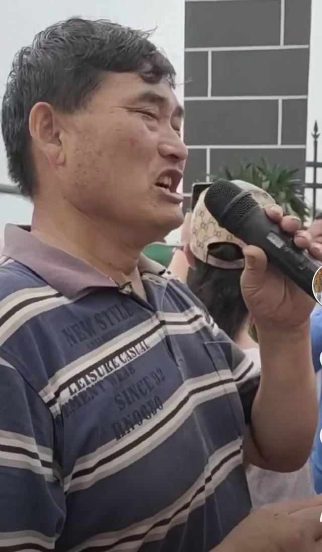 大衣哥耐心教村民唱歌，身后未建成小楼抢镜，唱歌干活两不误