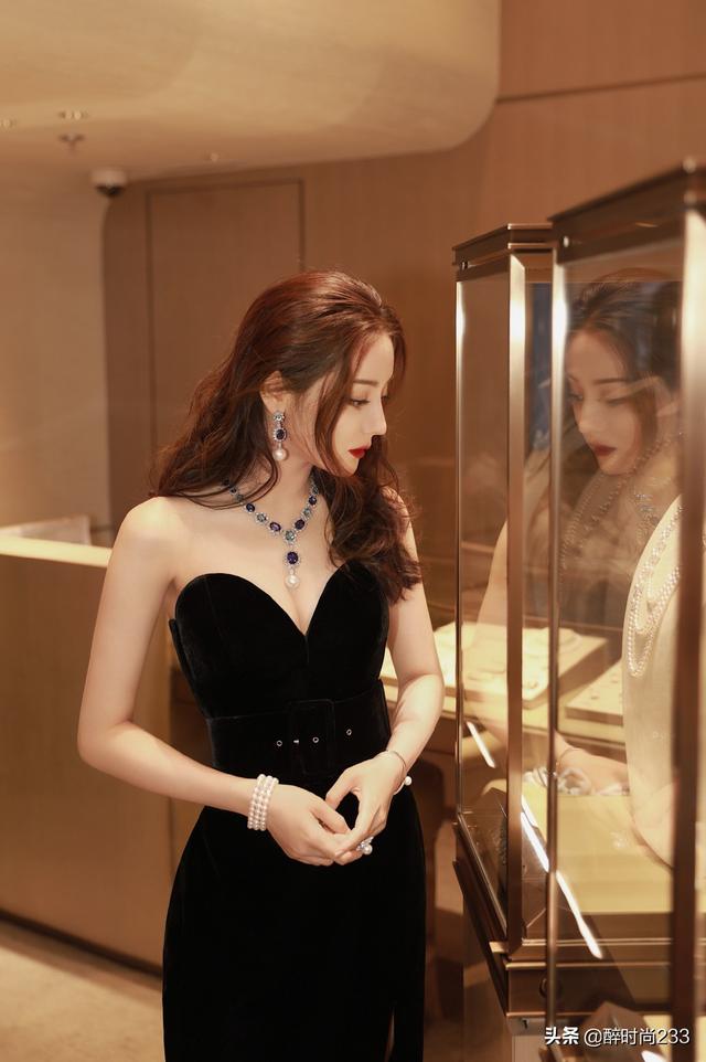 有一种心动叫迪丽热巴，一袭黑色深V抹胸长裙搭长卷发，高贵冷艳