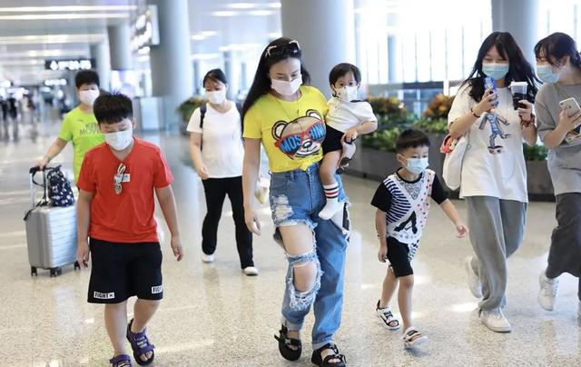 冉莹颖现身机场，戴墨镜配破洞裤穿搭时尚，一人带三娃妈妈力max