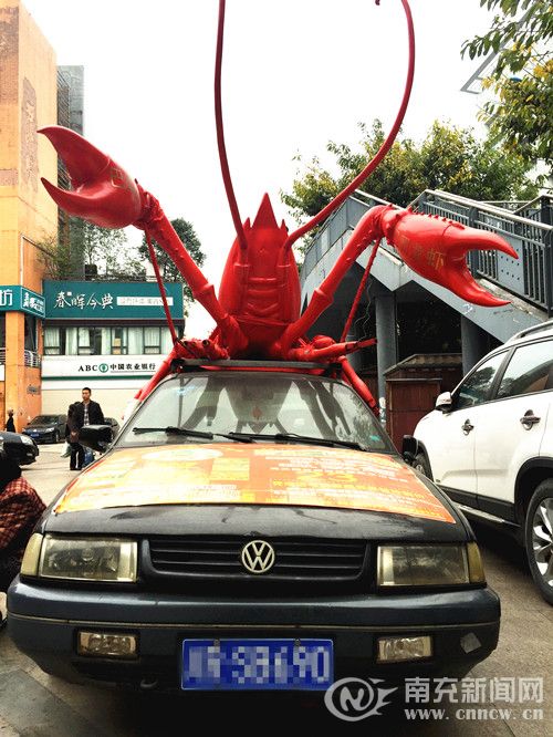 南充“僵尸车”有了新用途 商家车顶摆上“大龙虾”