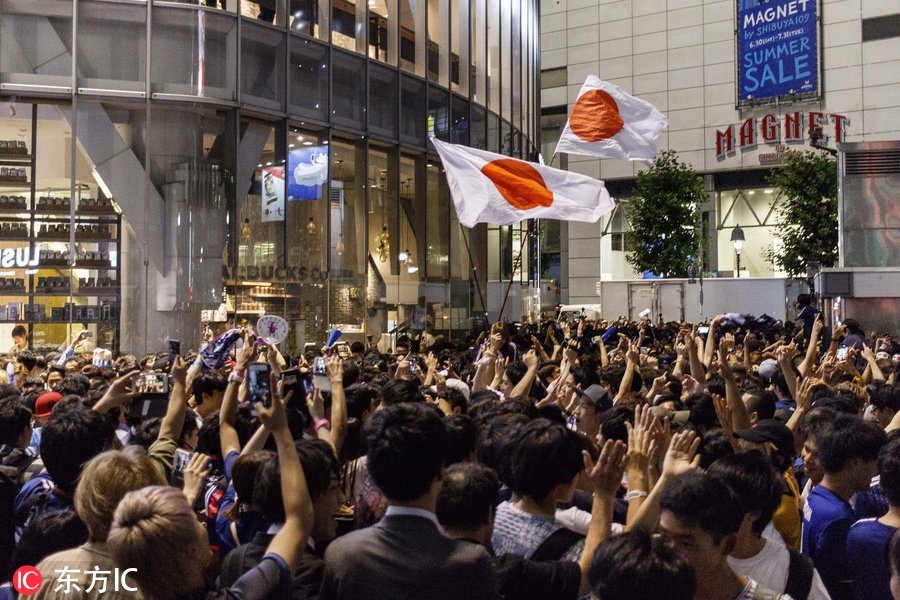 日本世界杯球迷(日本球迷街头狂欢庆祝第三次世界杯小组出线 大量警力维持秩序)