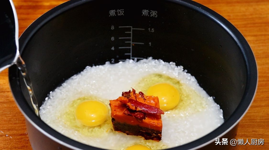 這是懶人燜飯的做法，大米里加一塊火鍋底料，打入3個雞蛋