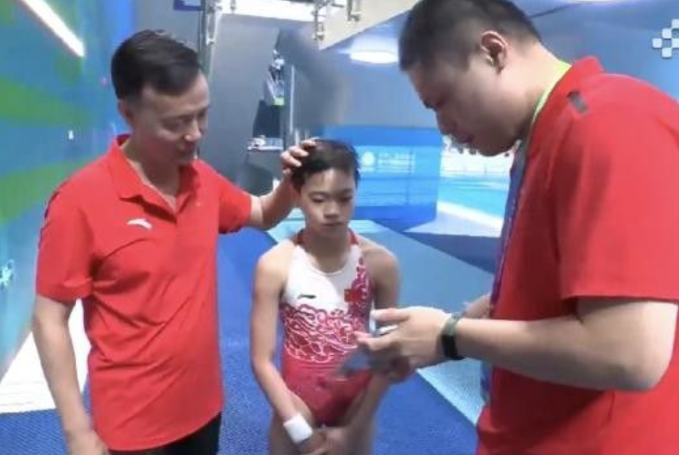 全红婵到教练家做蛋糕，脸伸进模具做鬼脸，教练双手叉腰温柔注视