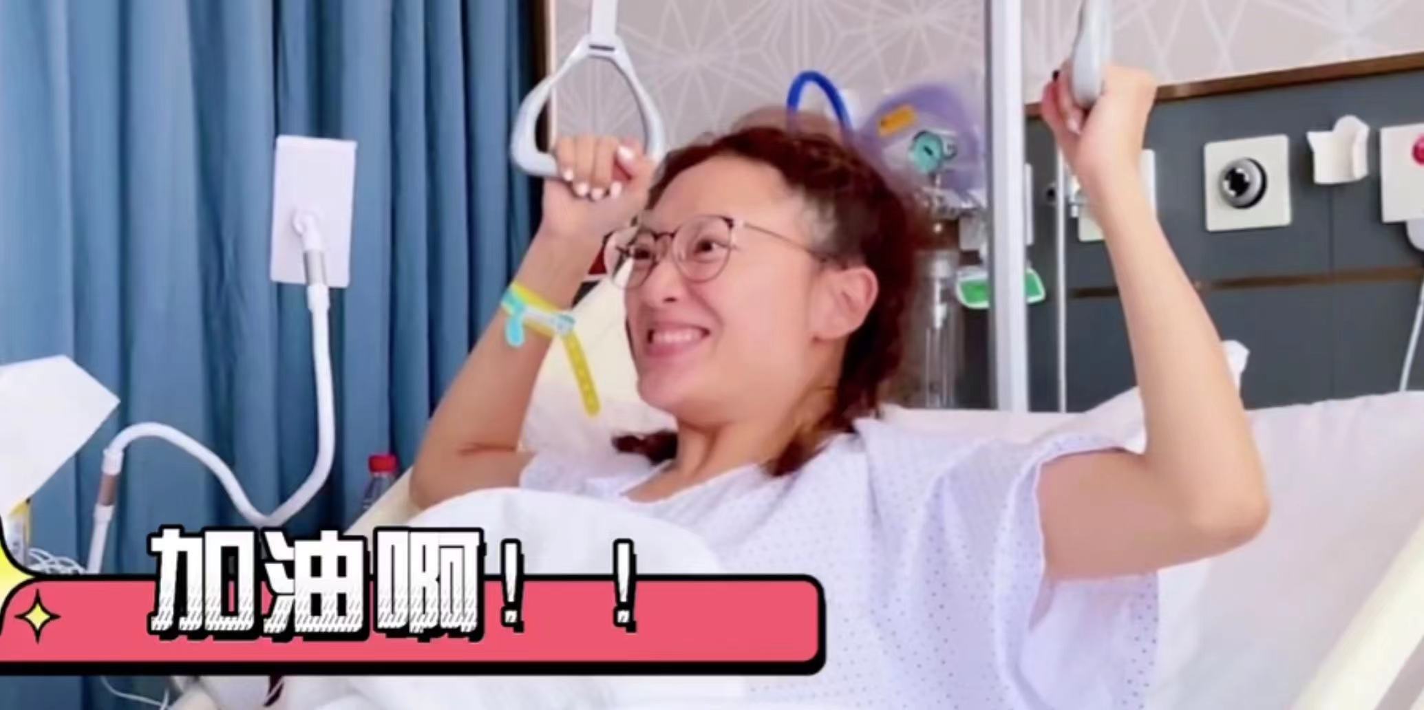 38岁应采儿双腿打石膏，半卧病床进行康复训练，病房内追看奥运会