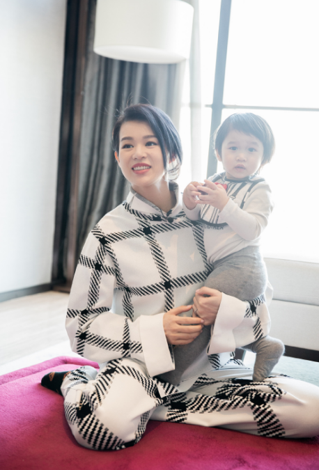 三胎孕媽胡杏兒帶兒子工作，穿著寬鬆巧遮孕肚，單手抱娃臂力足