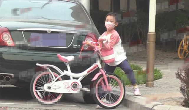 7岁甜馨相当独立，街头骑单车又美又飒，使劲抬