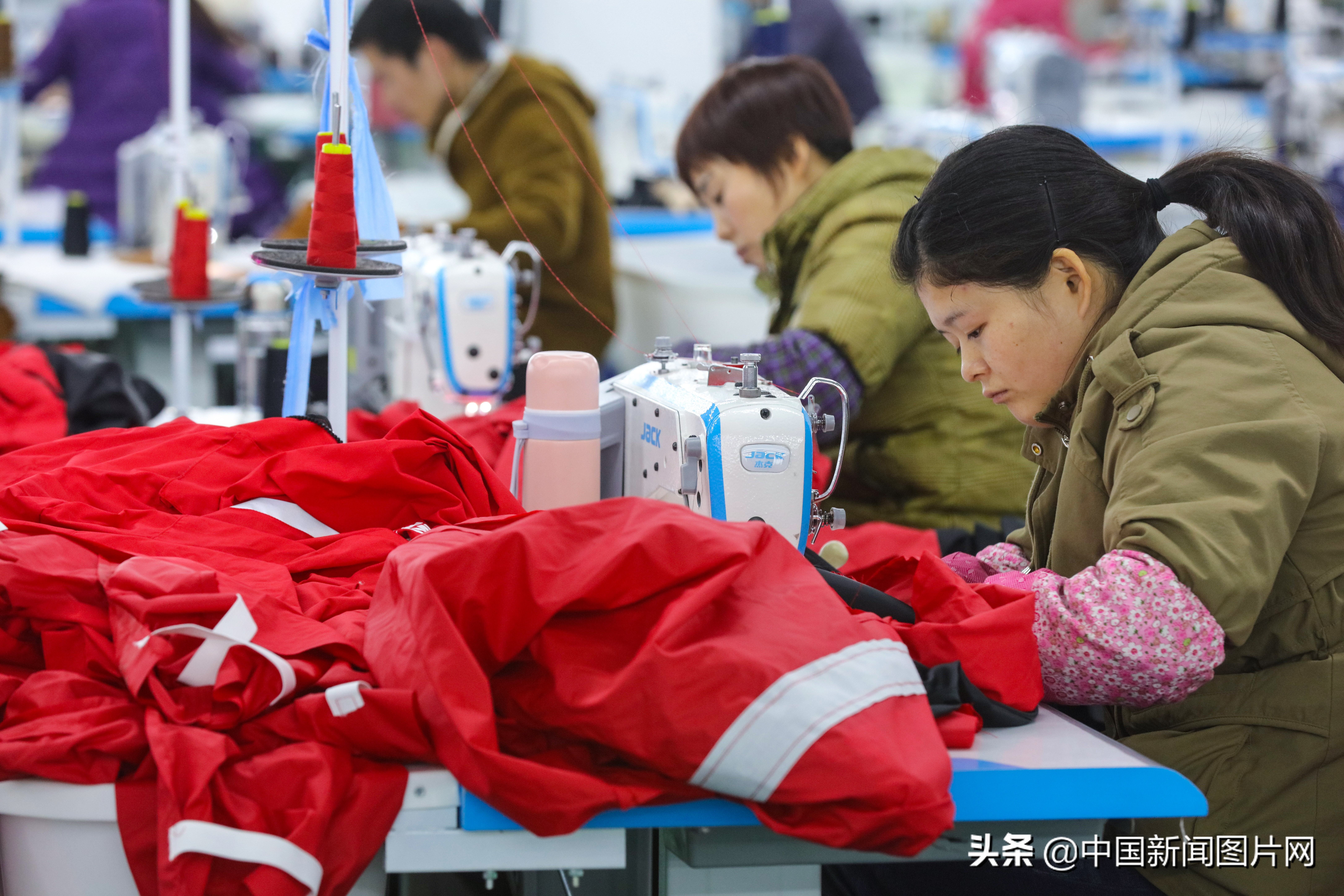 市光山县产业集聚区的良友服饰扶贫车间里工人正在赶做客户订单羽绒服