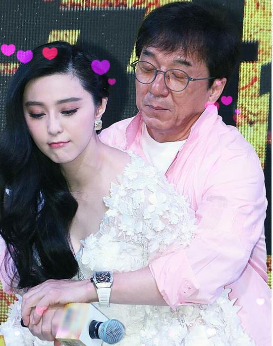 成龙与女团合影略显亲密，搭肩搂腰被批行为不当，表情像复制粘贴