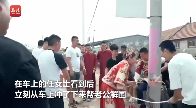 新郎遇婚闹被绑电线杆，新娘拿棍子帮其解围！网友：真解气