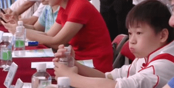 太逗！全红婵参会时无聊，自己玩水喝，发现被偷拍后立马把水咽了