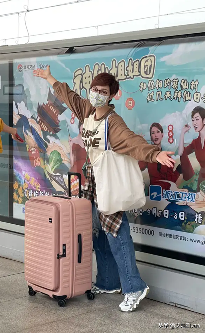 陈法蓉坐高铁旅行，穿拼接卫衣牛仔裤，站台上见自己海报俏皮合拍