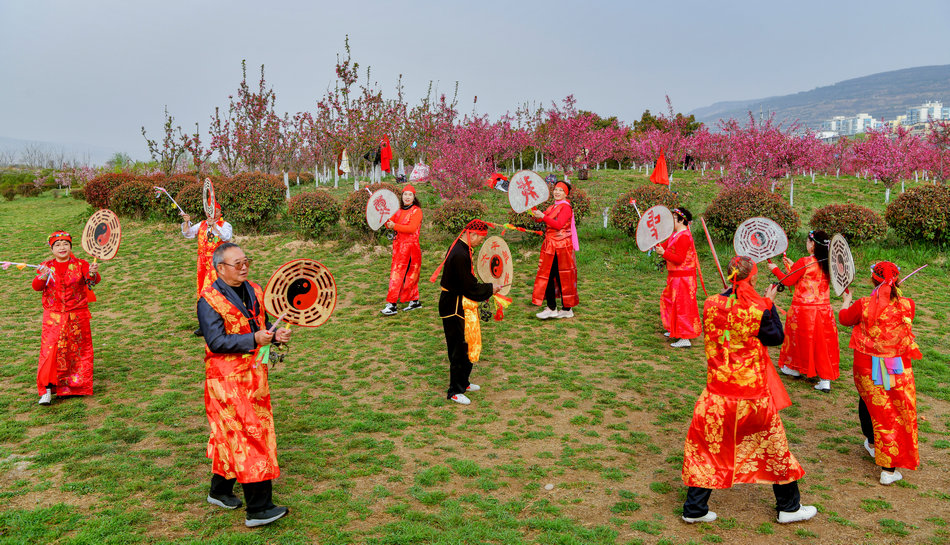 翠湖：桃花灼灼春色美，扇鼓咚咚夕阳红