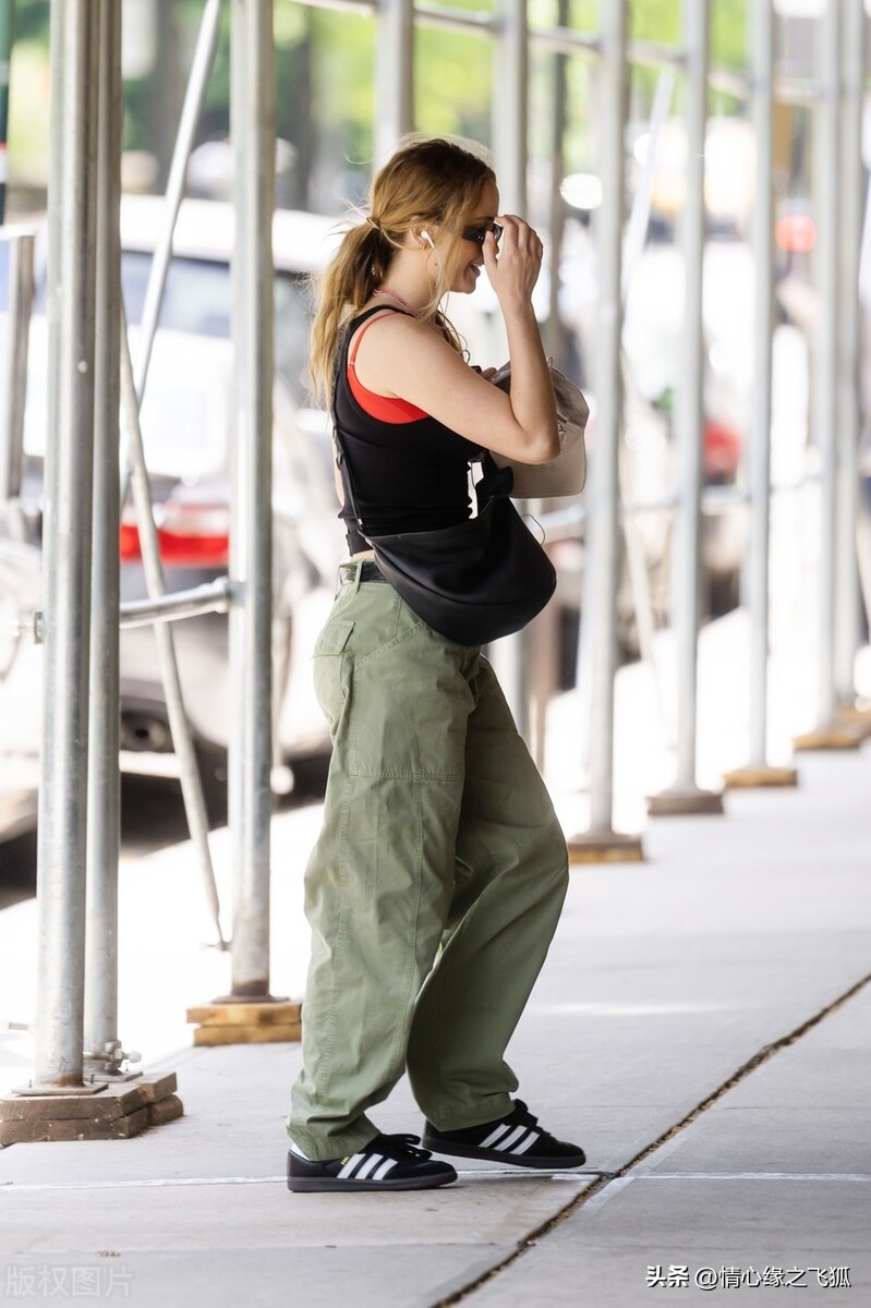 Jennifer Lawrence is wearing a black vest + army green overalls + black ...