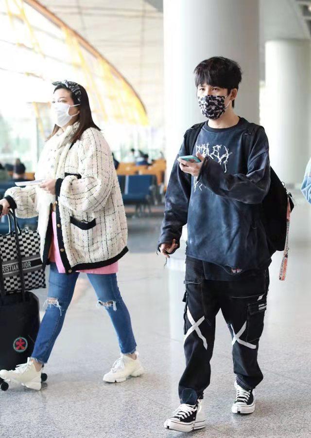 Da Zhangwei and his wife walk to the airport, the black and white match ...