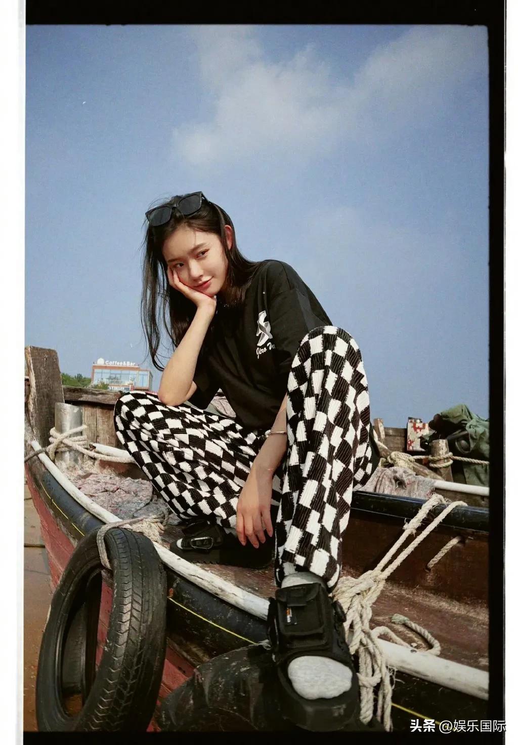 Lin Yun basks in the beach and wears sunglasses while squatting on a ...