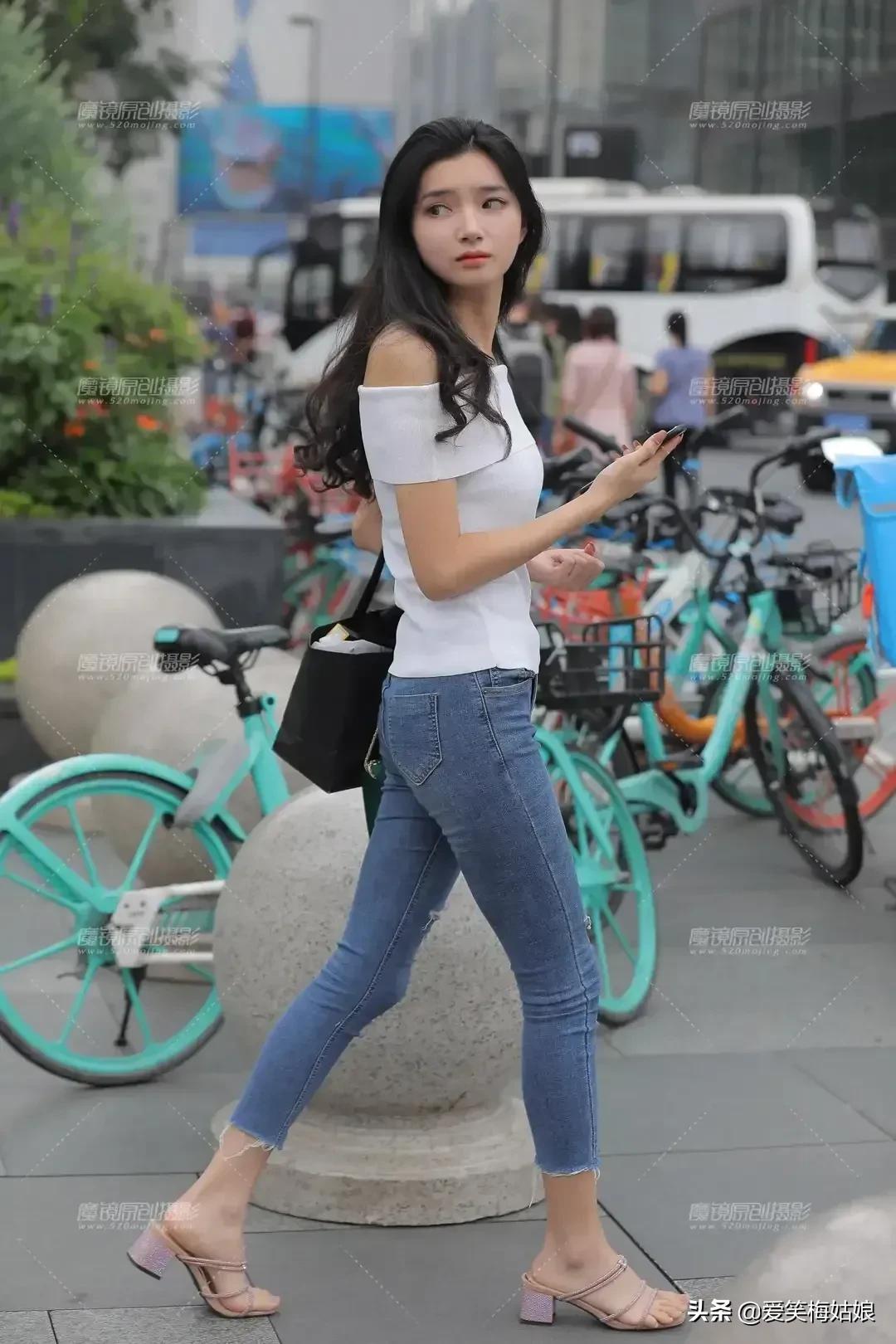 Street shot of a white knitted one-shoulder top with seven-point jeans ...