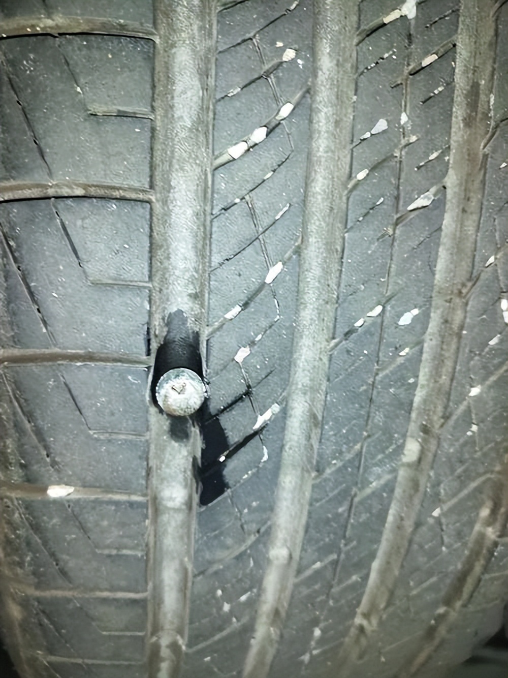 The tire is punctured by a nail and needs to be repaired immediately